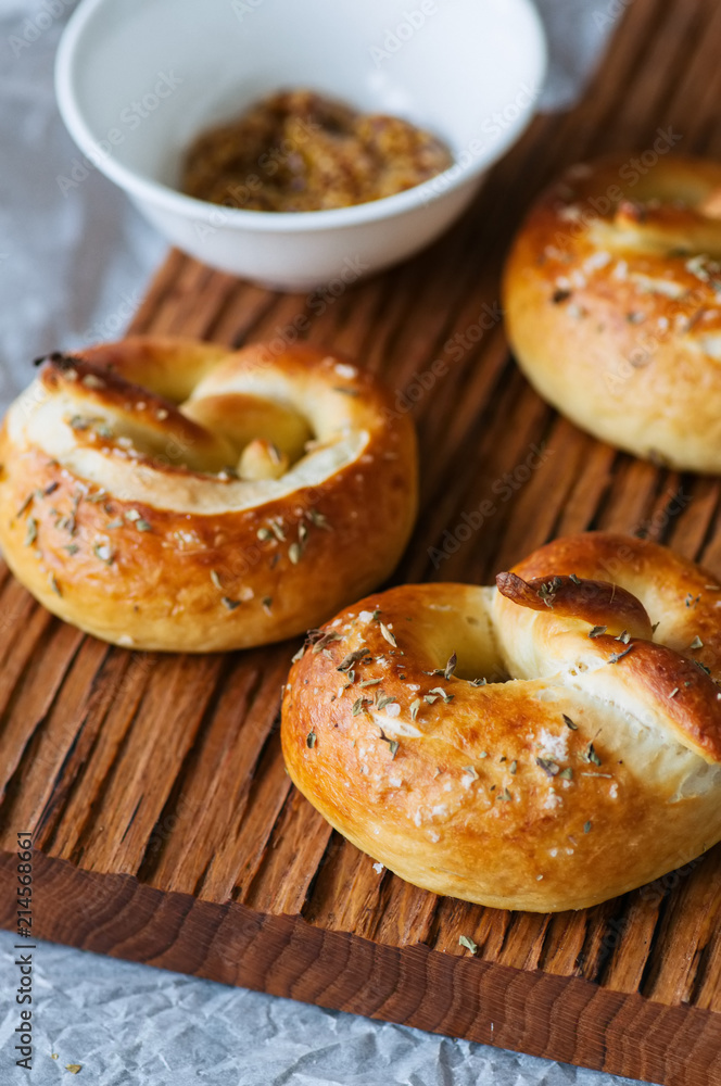 Traditional salted pretzels with oregano over wooden background. Oktoberfest or beer snack concept.
