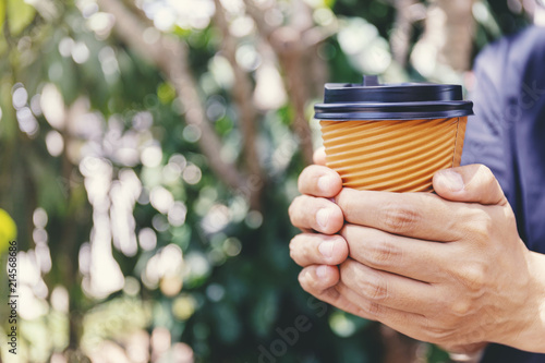 Close-up of male hand holding a paper cup of coffee to take away. © ilovewinter