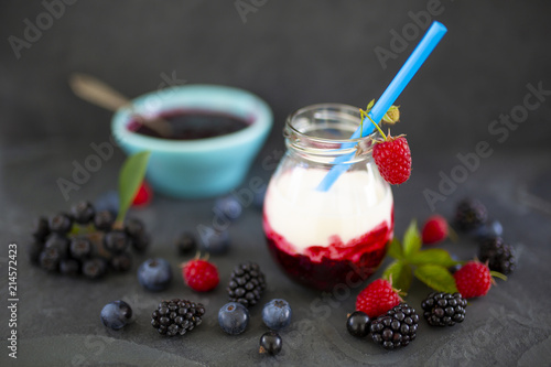Yogurt with fresh berries fruit on stone background. 