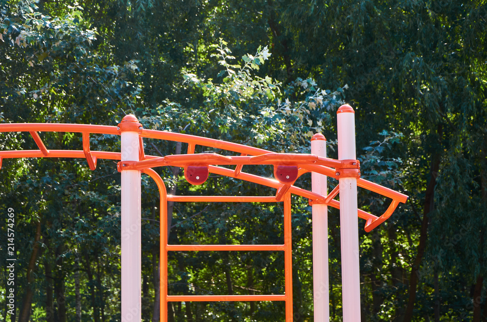 Orange outdoor fitness equipment in public park Orange outdoor fitness equipment in public park