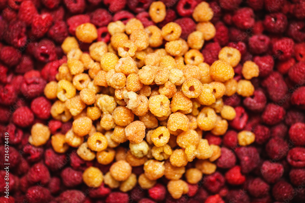 bunch of yellow raspberries lies in middle of red raspberries bunch of yellow raspberries lies in middle of red raspberries