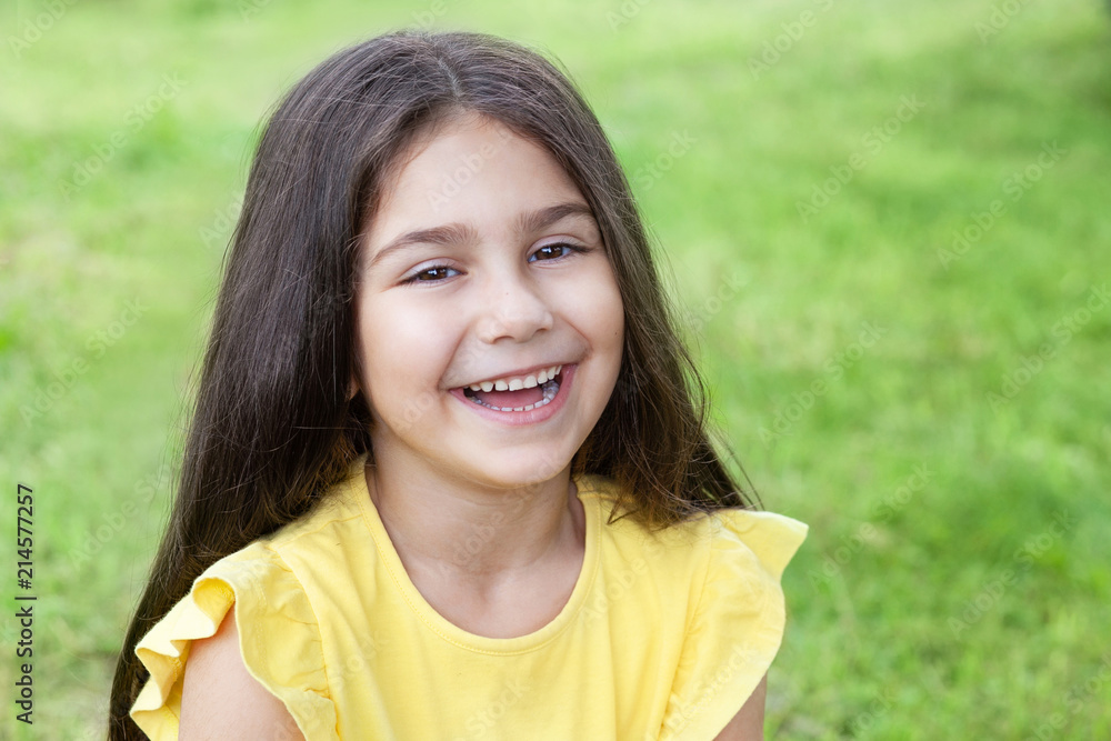 Portrait of a happy smiling child girl outdoors. Cute little girl playing in the park. Portrait of a happy smiling child girl outdoors. Cute little girl playing in the park.