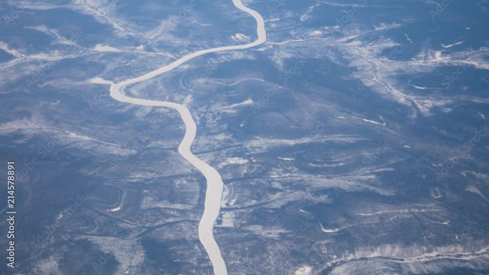 View From The Window Of The Aircraft On The Winter Land With Ice-Covered River View From The Window Of The Aircraft On The Winter Land With Ice-Covered River