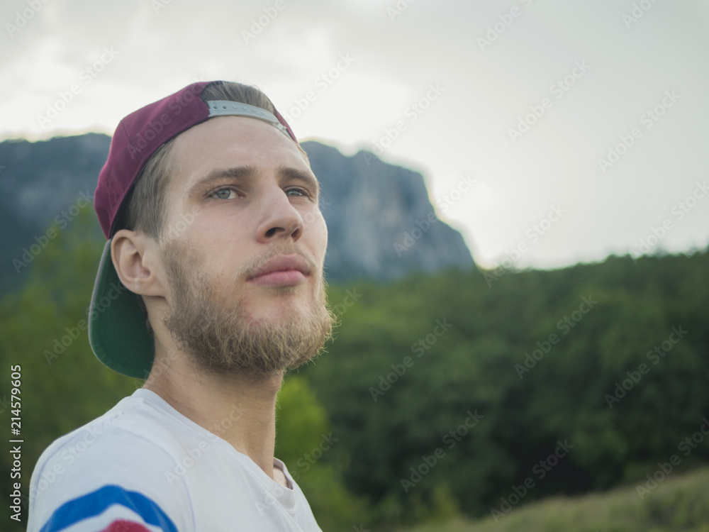 close portrait of young bearded man in casual walking in the summer mountain field close portrait of young bearded man in casual walking in the summer mountain field