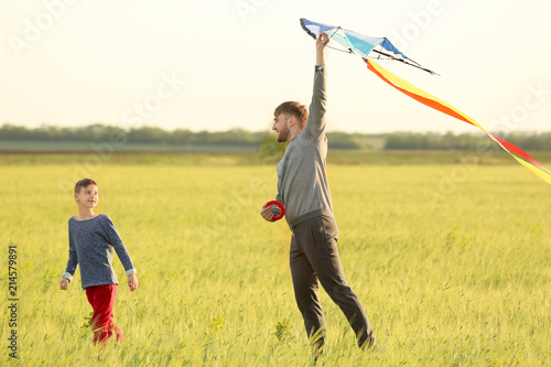 Father and son flying kite ...