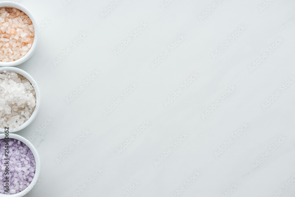 top view of colorful sea salt in bowls on white background top view of colorful sea salt in bowls on white background