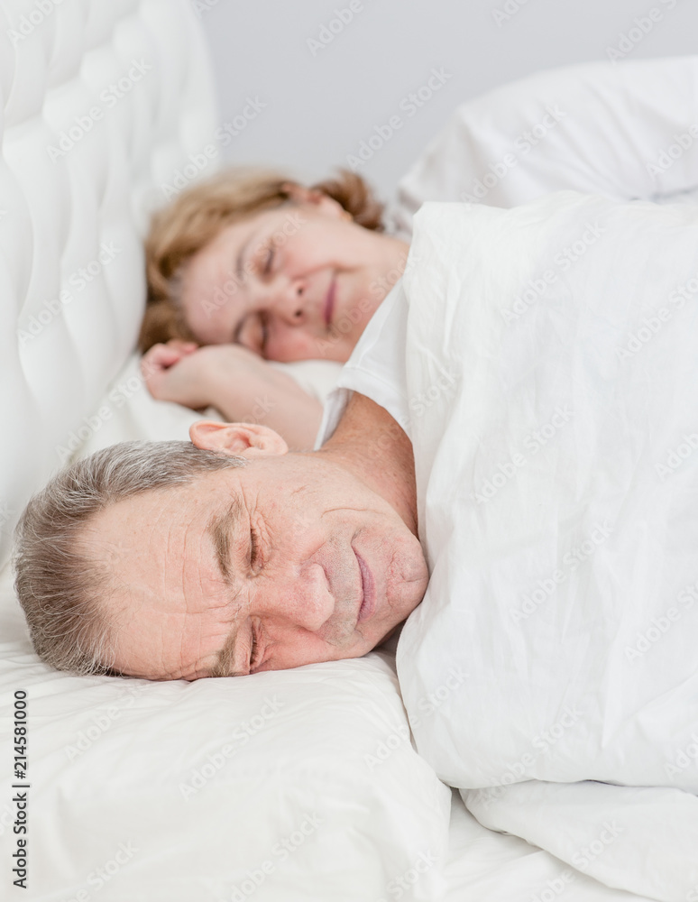Happy elderly couple sleeping together on the bed Happy elderly couple sleeping together on the bed