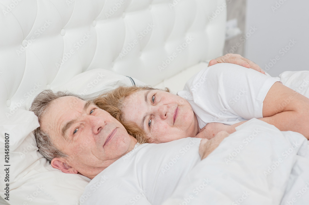 elderly couple lying together on the bed elderly couple lying together on the bed