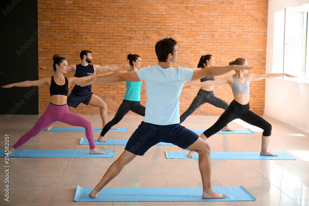 Obraz premium Group of people practicing yoga in gym