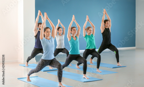 Group of people practicing yoga in gym