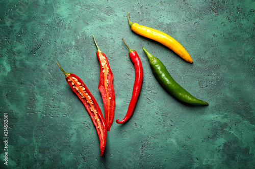 Fresh chili peppers on green background