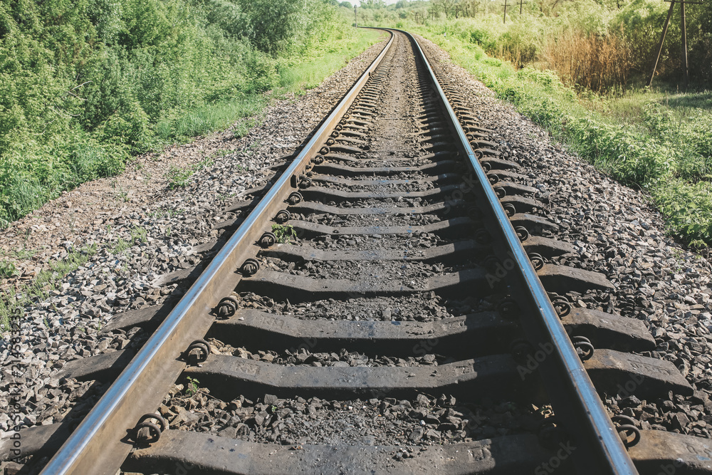 Rail tracks in the green field. Railway transport industry. Empty road on summer day. Travel lifestyle motivation photo. Rail tracks in the green field. Railway transport industry. Empty road on summer day. Travel lifestyle motivation photo.