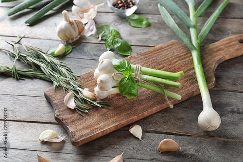 Composition with green onion and fresh herbs on wooden background