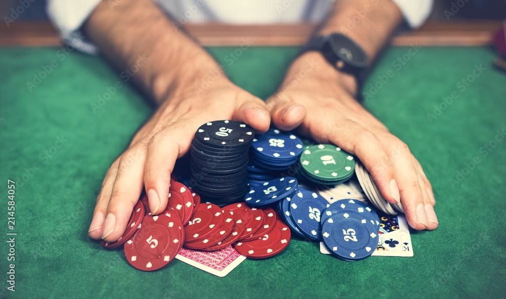 Closeup of hands with gambling tokens and card Closeup of hands with gambling tokens and card