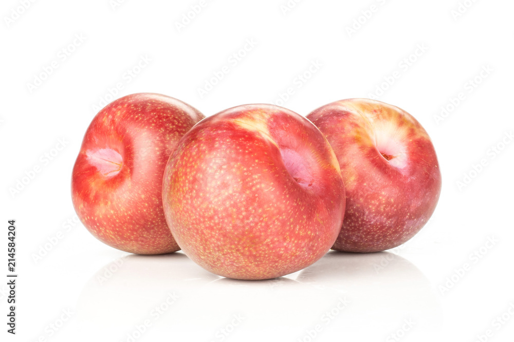 Group of three whole fresh pluot interspecific plums variety stack isolated on white
