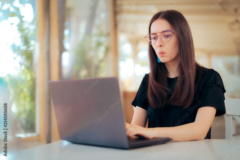 Freelance Woman Working Online Typing on Laptop in a Restaurant Freelance Woman Working Online Typing on Laptop in a Restaurant