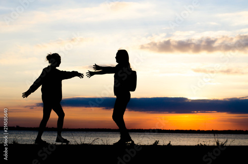 Couple woman silhouette hug because nostalgia during sunset and beautiful sky.