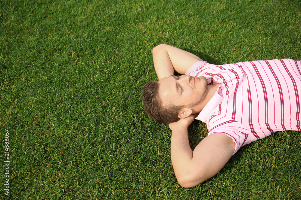 Young man relaxing on green grass outdoors Young man relaxing on green grass outdoors