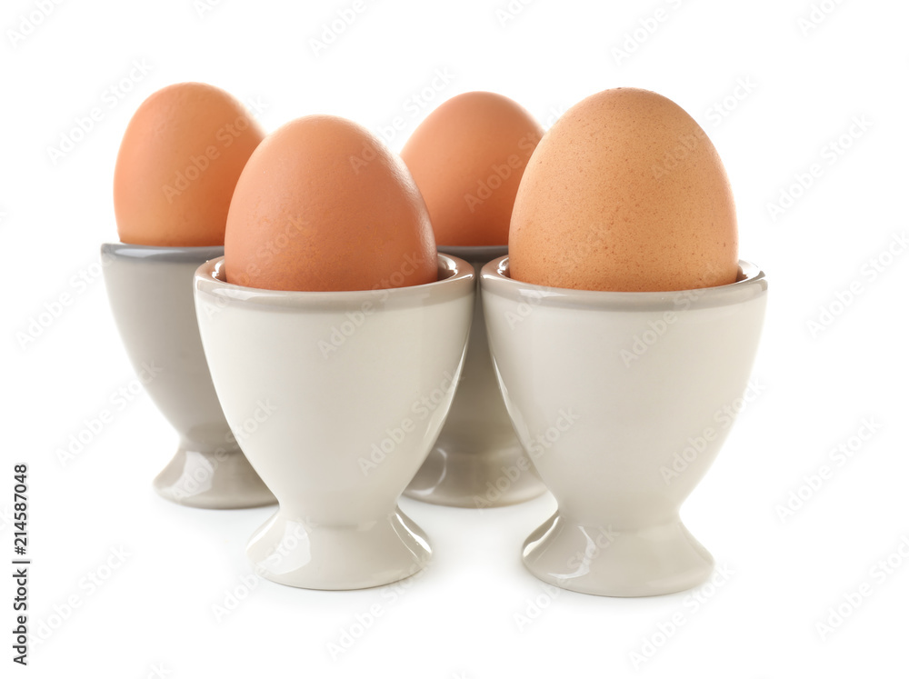 Ceramic holders with chicken eggs on white background Ceramic holders with chicken eggs on white background