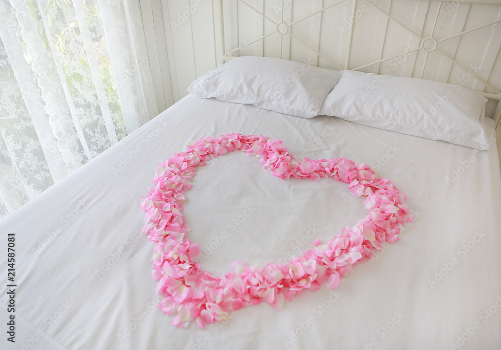 Heart of red petals on a bed. Honeymoon. Heart of red petals on a bed. Honeymoon.