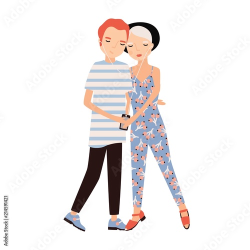 Young man and woman dressed in trendy clothes listening to music using earpho...