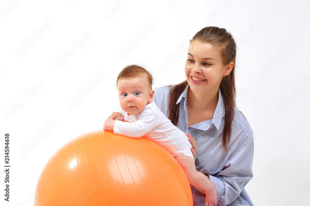 Mom and baby doing gymnastics on an orange fitball. Mom and baby doing gymnastics on an orange fitball.