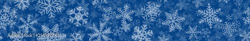 Christmas horizontal seamless banner of many layers of snowflakes of different shapes, sizes and transparency. White on blue.