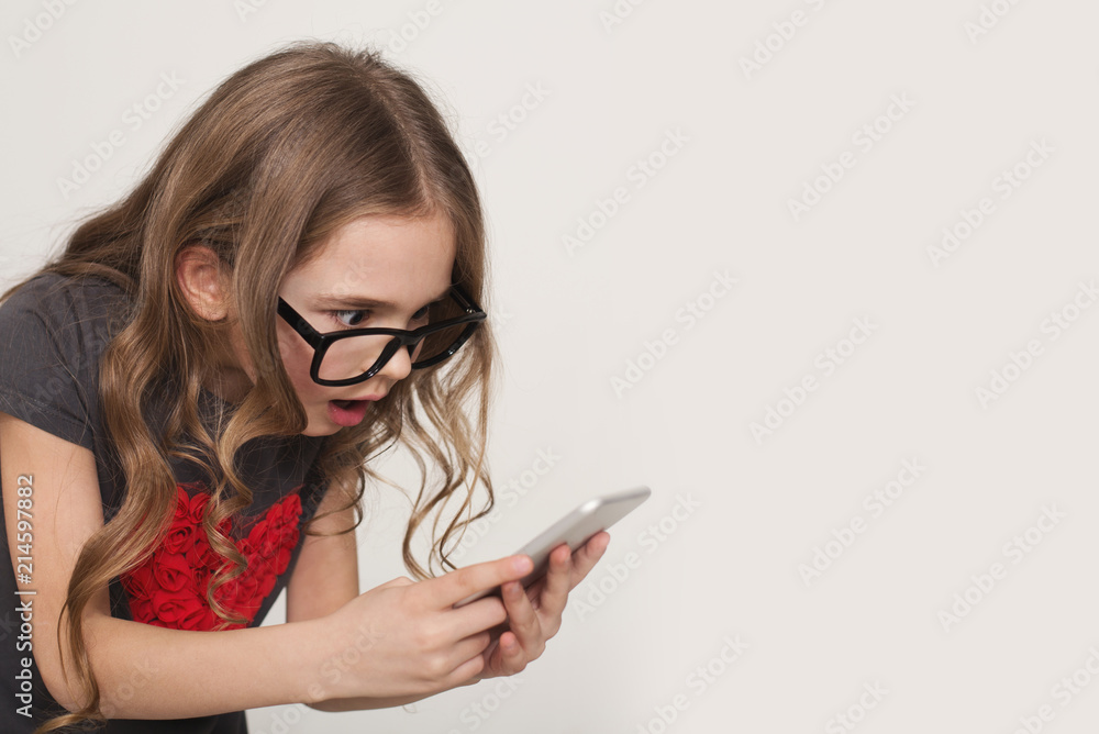 Little girl looking at mobile phone screen Little girl looking at mobile phone screen