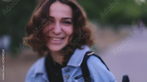 Woman listening greeting or compliment and take a flower. Celebration and presents. Curly woman wearing black dress and blue jeans jacket.
