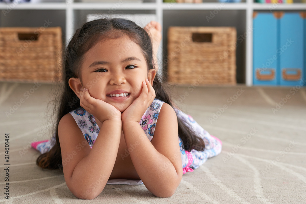 Portrait of cute smiling little girl lying on the floor at home Portrait of cute smiling little girl lying on the floor at home