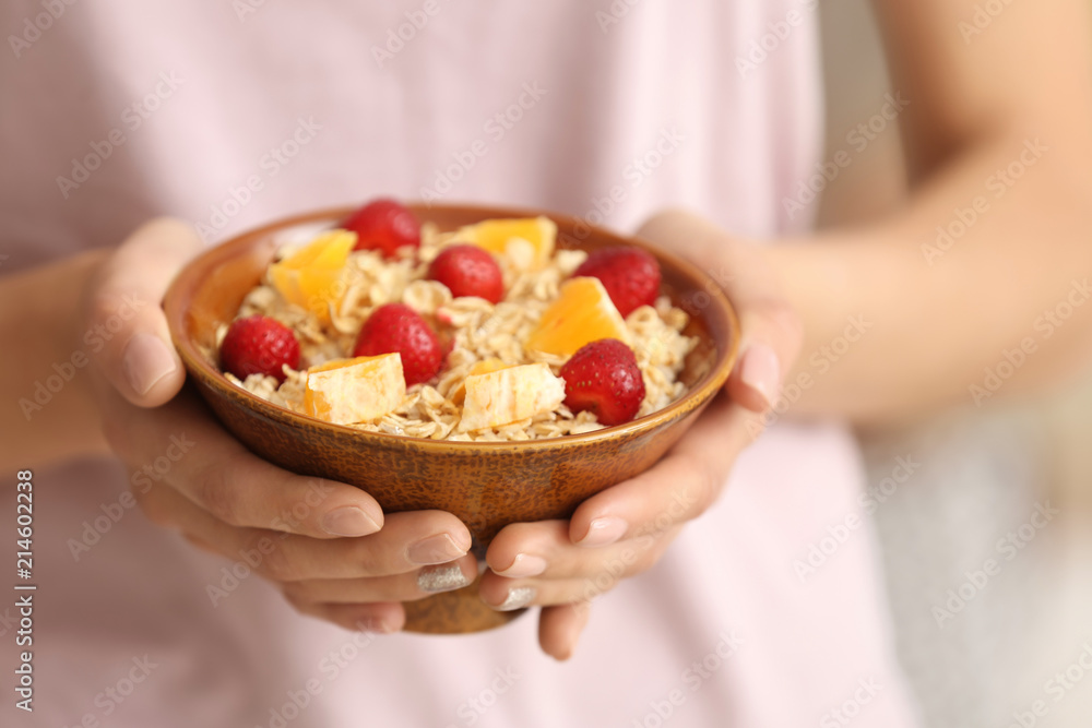 Young woman with bowl of tasty oatmeal, closeup Young woman with bowl of tasty oatmeal, closeup