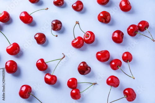 Flat lay composition with ripe cherries on color background