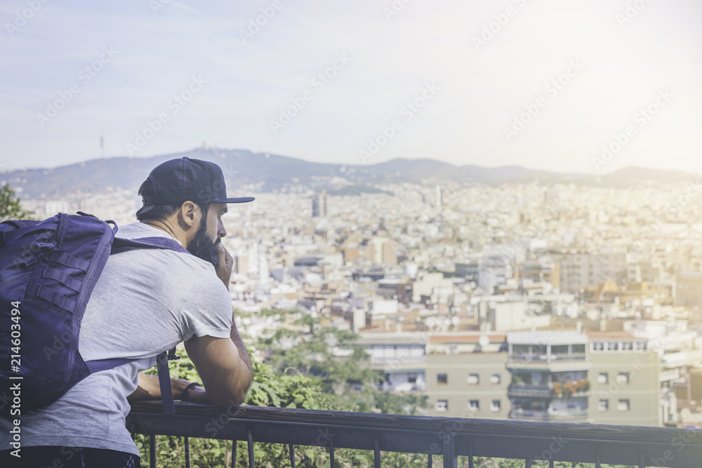 Traveler man looking on a big city, travel and active lifestyle concept.Bearded Tourist Man with backpack enjoy beautiful city view