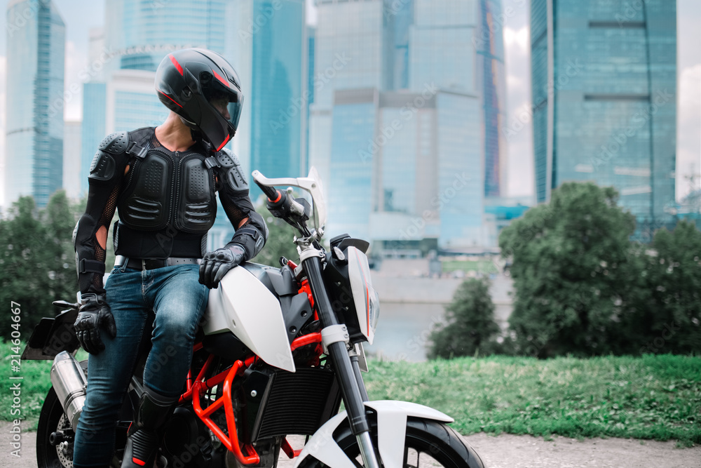 Fototapeta premium Biker and motorcycle near downtown city urban district
