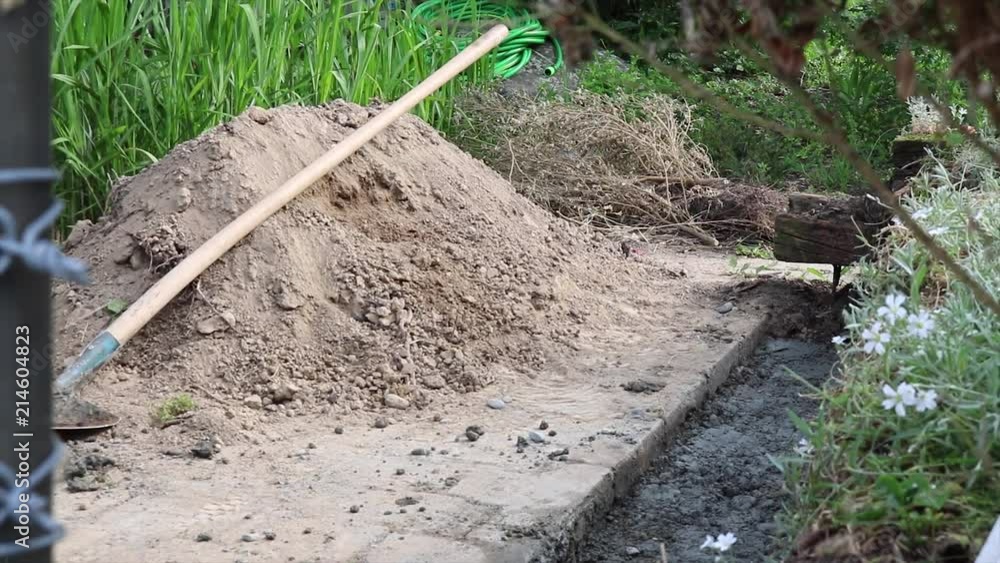 Construction worker in a field moving a wheelbarrow. Construction worker in a field moving a wheelbarrow.