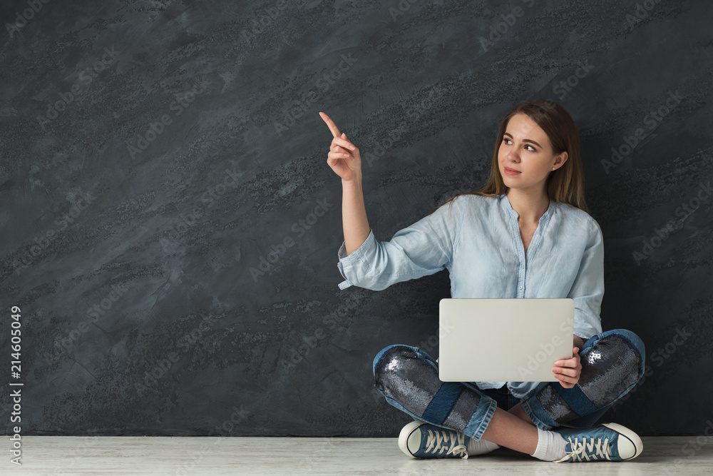 Young woman with laptop showing place for advertisement Young woman with laptop showing place for advertisement