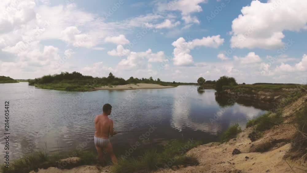 the fisherman is fishing on the river by spinning. the fisherman is fishing on the river by spinning.