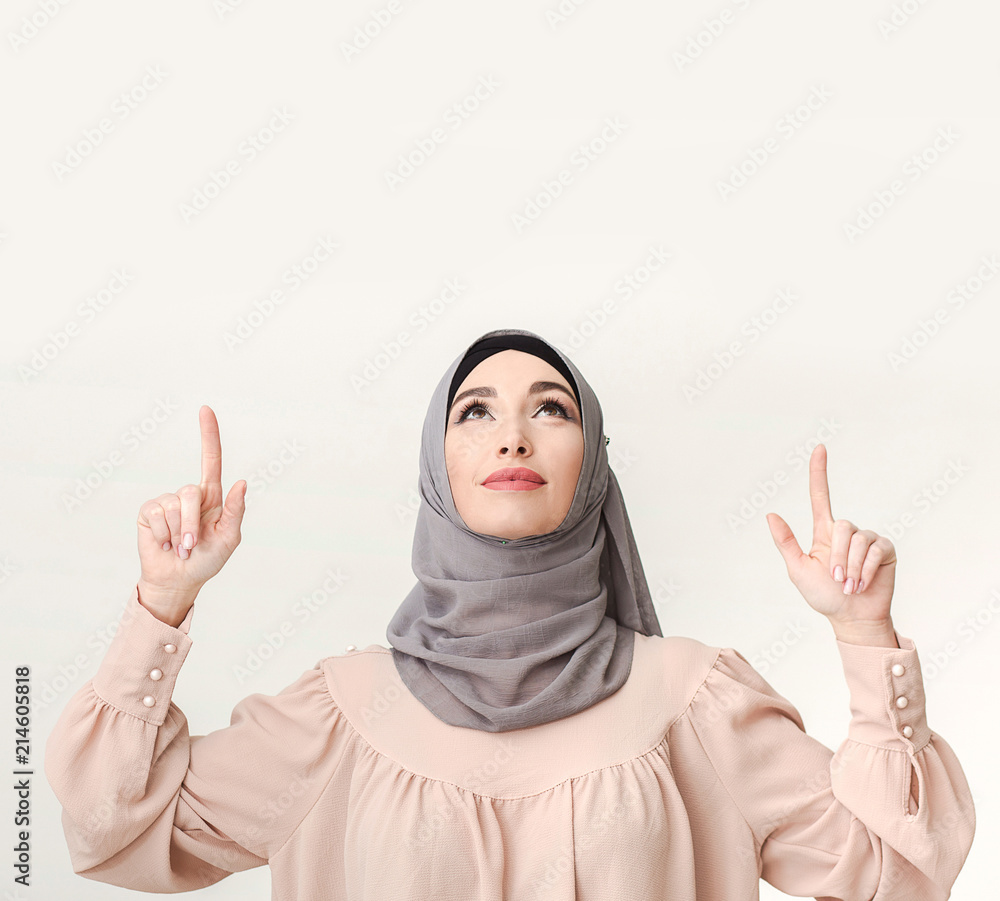 Arab woman pointing on blank white space Arab woman pointing on blank white space