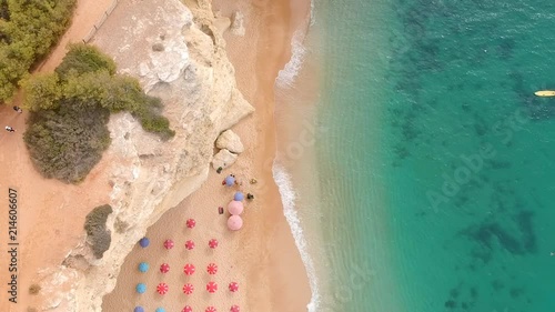 Drone shot of a beach with parasols in Algarve, Portugal. PANING TOP TO BOTTOM
