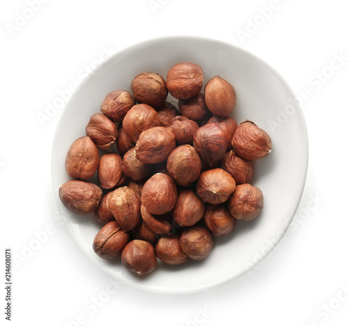 Bowl with tasty hazelnuts on white background