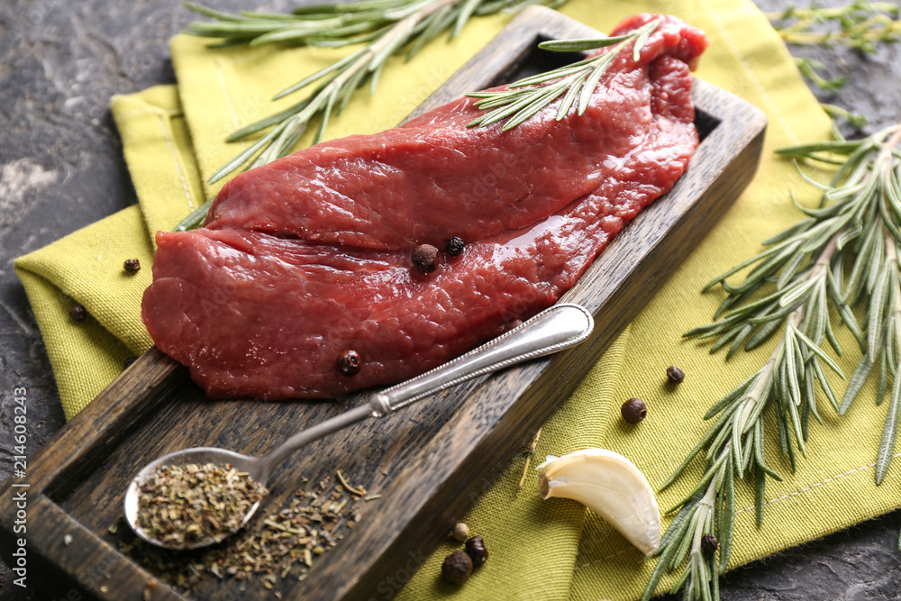 Fresh raw meat with spices and herbs on grey background