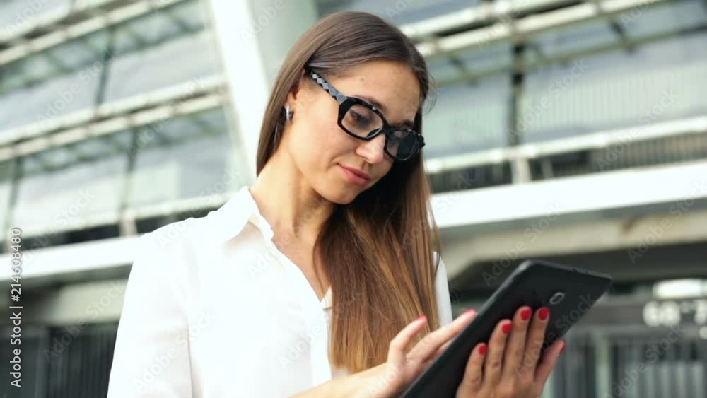 Business woman standing, working with tablet computer. Business woman standing, working with tablet computer.