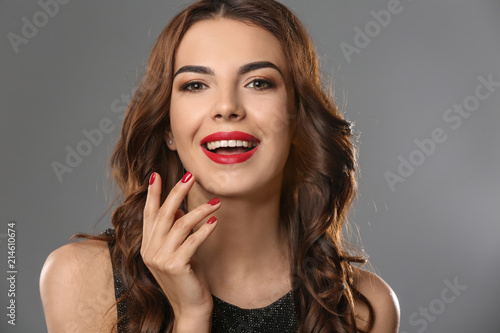 Young woman with beautiful manicure on grey background