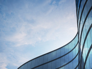 Perspective of high rise building and dark steel window system with clouds reflected on the glass.Business concept of future architecture,lookup to the angle of the building corner. 3d rendering