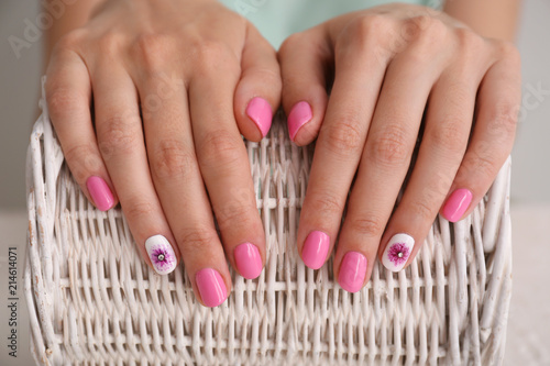 Female hands with stylish color nails on wicker basket  closeup