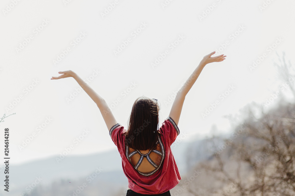 happy stylish hipster woman standing on top of hill mountain and raising hands up, cheerful moment of happiness happy stylish hipster woman standing on top of hill mountain and raising hands up, cheerful moment of happiness