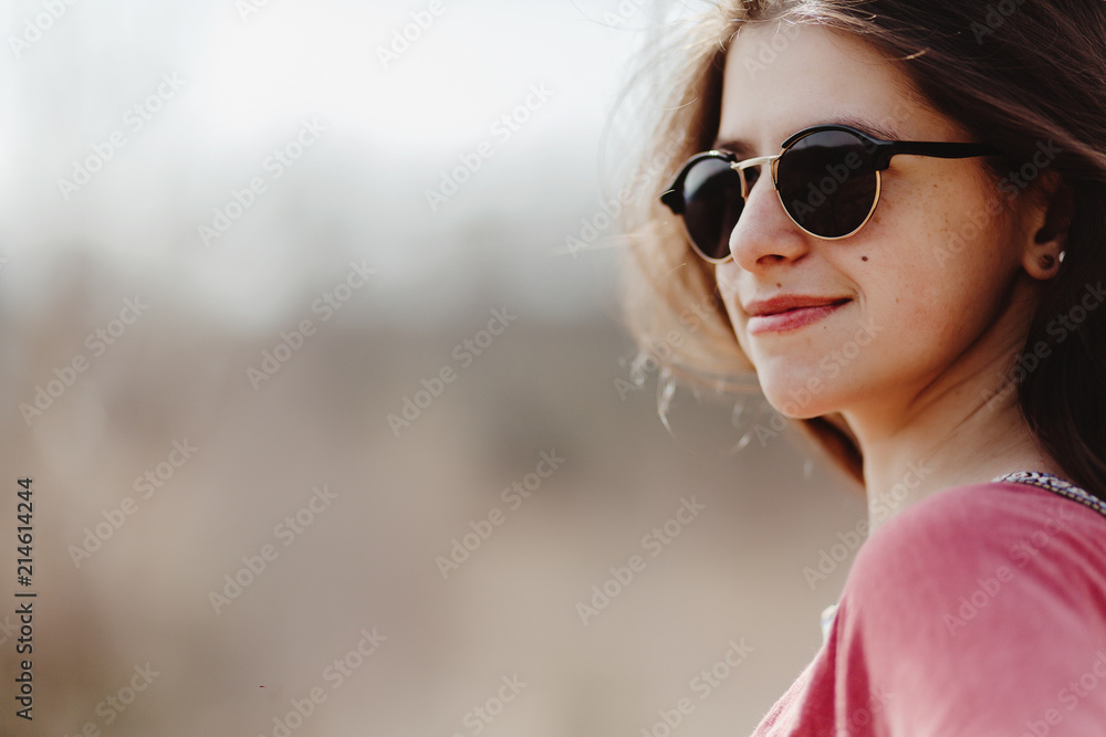beautiful stylish woman hipster smiling portrait in fashionable sunglasses in summer mountains, space for text travel concept