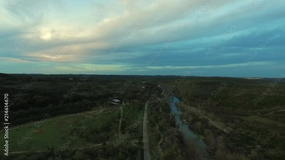 Drone filming a decent by river in Paradise canyon around or just before sunset with a beautiful sky.