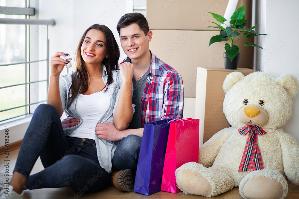 Happy young couple unpacking or packing boxes and moving into a new home Happy young couple unpacking or packing boxes and moving into a new home