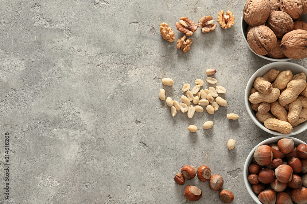 Bowls with different tasty nuts on light background Bowls with different tasty nuts on light background